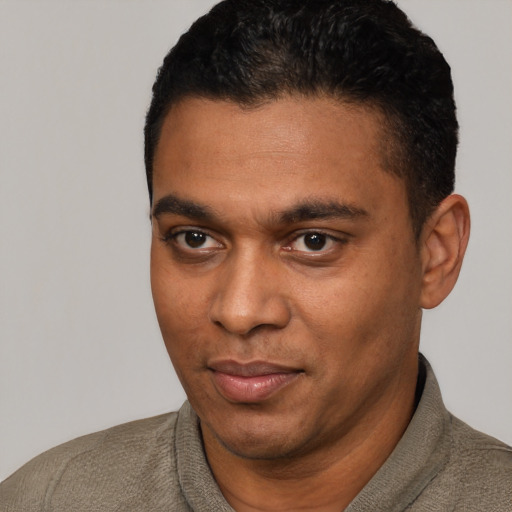 Joyful black young-adult male with short  black hair and brown eyes