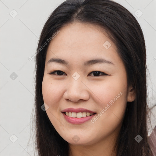 Joyful asian young-adult female with long  brown hair and brown eyes