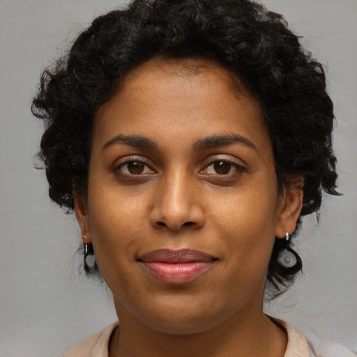 Joyful black young-adult female with medium  brown hair and brown eyes