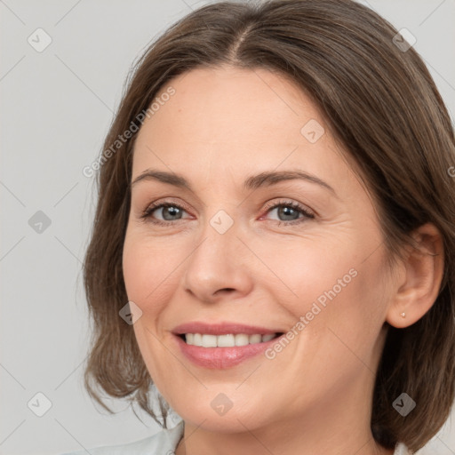 Joyful white adult female with medium  brown hair and grey eyes