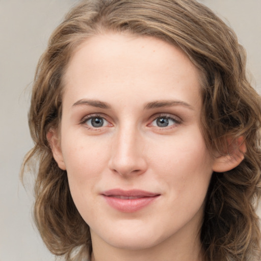 Joyful white young-adult female with medium  brown hair and green eyes