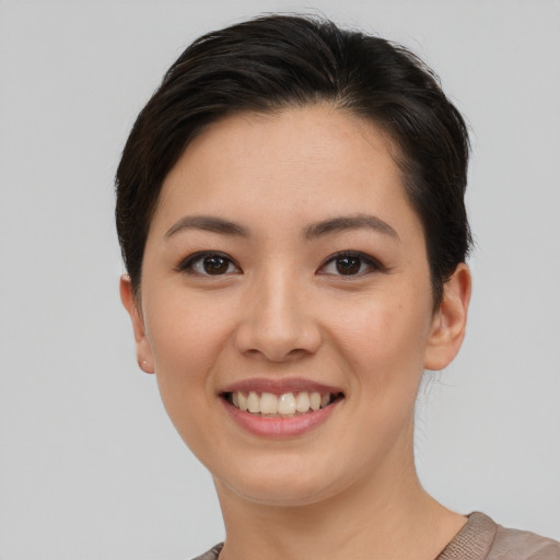 Joyful asian young-adult female with short  brown hair and brown eyes