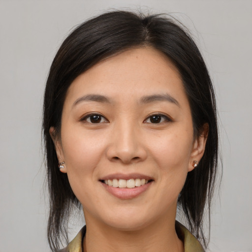 Joyful asian young-adult female with medium  brown hair and brown eyes