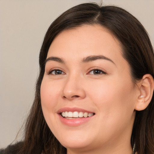 Joyful white young-adult female with long  brown hair and brown eyes