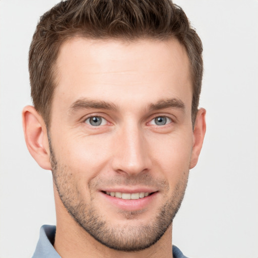 Joyful white young-adult male with short  brown hair and grey eyes