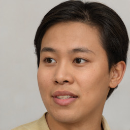 Joyful asian young-adult male with short  brown hair and brown eyes