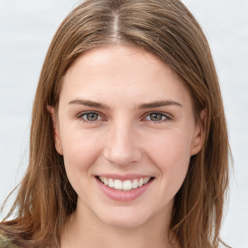 Joyful white young-adult female with long  brown hair and green eyes