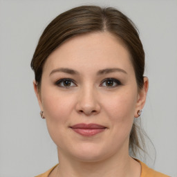 Joyful white young-adult female with medium  brown hair and grey eyes