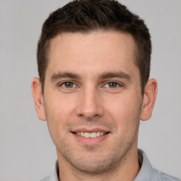 Joyful white young-adult male with short  brown hair and grey eyes