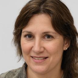 Joyful white adult female with medium  brown hair and grey eyes