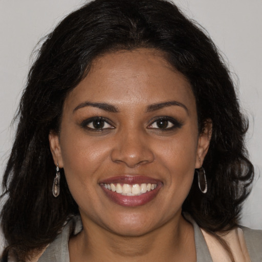 Joyful black young-adult female with medium  brown hair and brown eyes