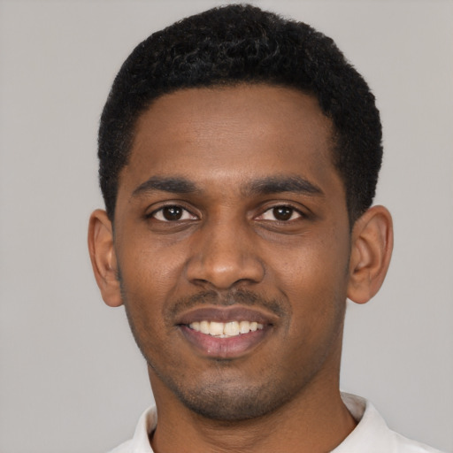 Joyful black young-adult male with short  black hair and brown eyes