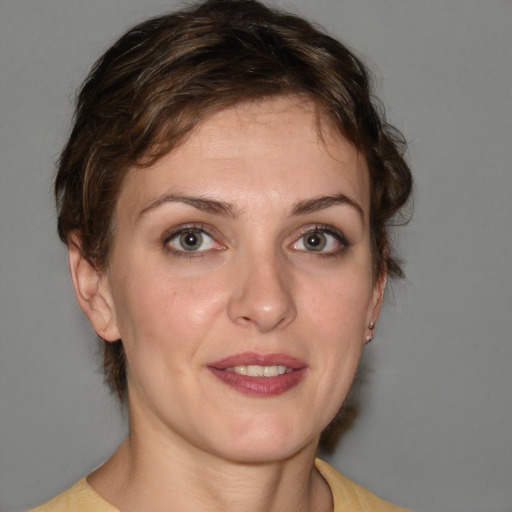 Joyful white young-adult female with medium  brown hair and grey eyes