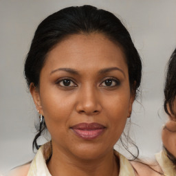 Joyful black adult female with medium  brown hair and brown eyes