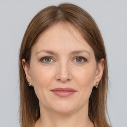 Joyful white adult female with long  brown hair and grey eyes