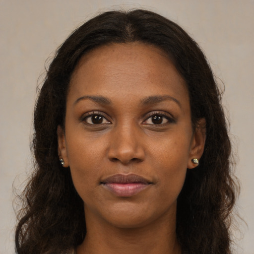 Joyful black young-adult female with long  brown hair and brown eyes