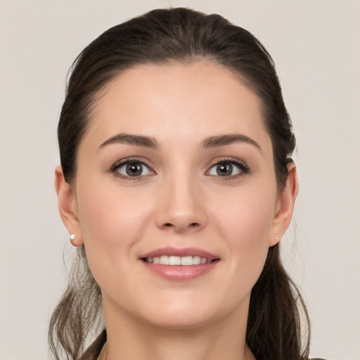 Joyful white young-adult female with long  brown hair and grey eyes