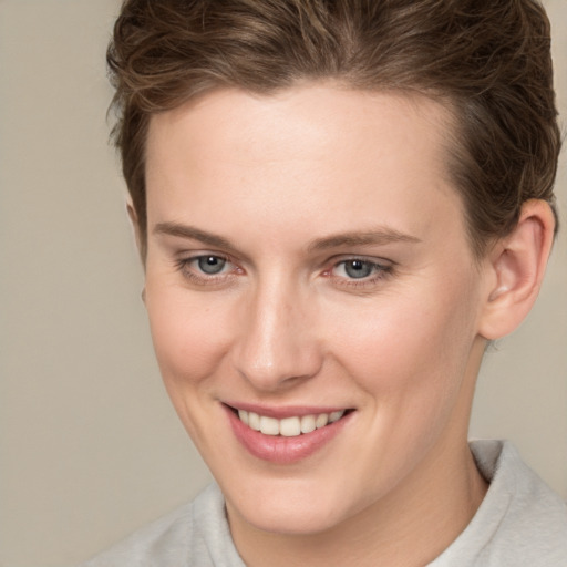 Joyful white young-adult female with short  brown hair and grey eyes