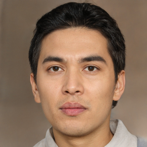 Joyful asian young-adult male with short  black hair and brown eyes