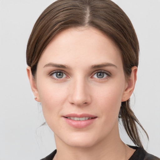 Joyful white young-adult female with medium  brown hair and grey eyes