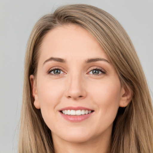 Joyful white young-adult female with long  brown hair and grey eyes