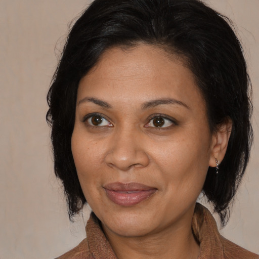 Joyful black adult female with medium  brown hair and brown eyes