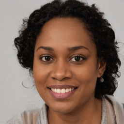 Joyful black young-adult female with long  brown hair and brown eyes