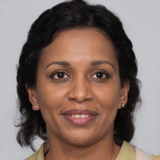 Joyful black adult female with medium  brown hair and brown eyes