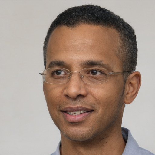 Joyful black adult male with short  black hair and brown eyes