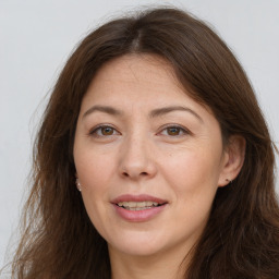 Joyful white adult female with long  brown hair and brown eyes