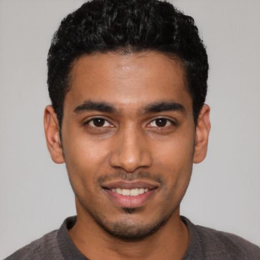 Joyful latino young-adult male with short  black hair and brown eyes