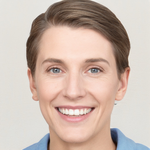 Joyful white young-adult female with short  brown hair and grey eyes