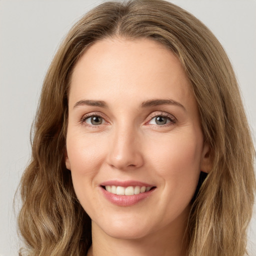 Joyful white young-adult female with long  brown hair and green eyes