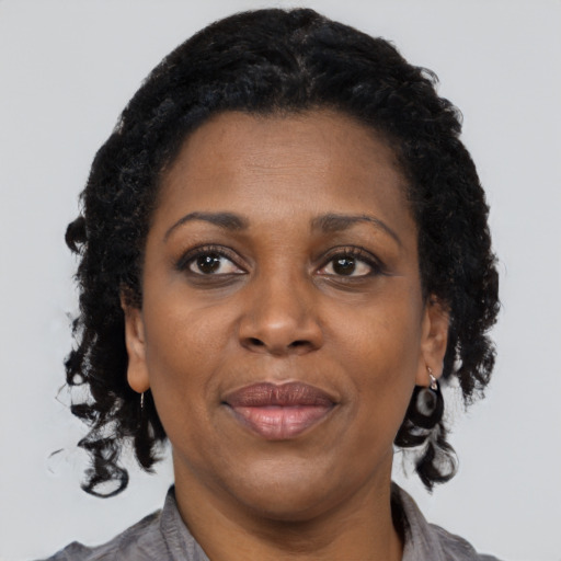 Joyful black adult female with short  brown hair and brown eyes