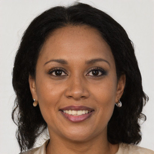 Joyful black adult female with medium  brown hair and brown eyes