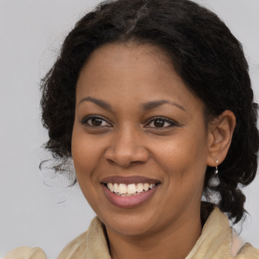 Joyful black young-adult female with long  brown hair and brown eyes