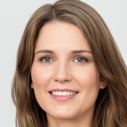 Joyful white young-adult female with long  brown hair and green eyes