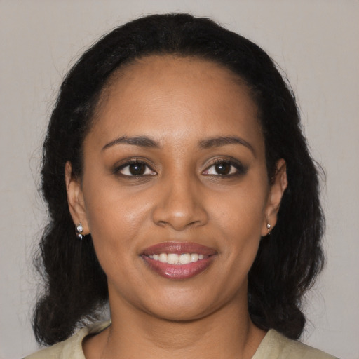 Joyful black young-adult female with long  black hair and brown eyes