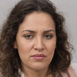 Joyful white adult female with long  brown hair and brown eyes