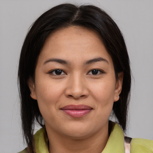 Joyful latino young-adult female with medium  brown hair and brown eyes