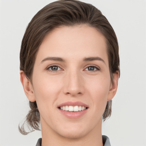 Joyful white young-adult female with medium  brown hair and grey eyes