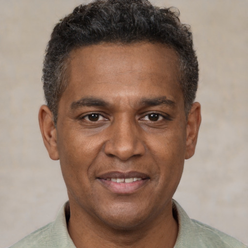 Joyful black young-adult male with short  brown hair and brown eyes