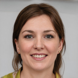 Joyful white young-adult female with medium  brown hair and grey eyes