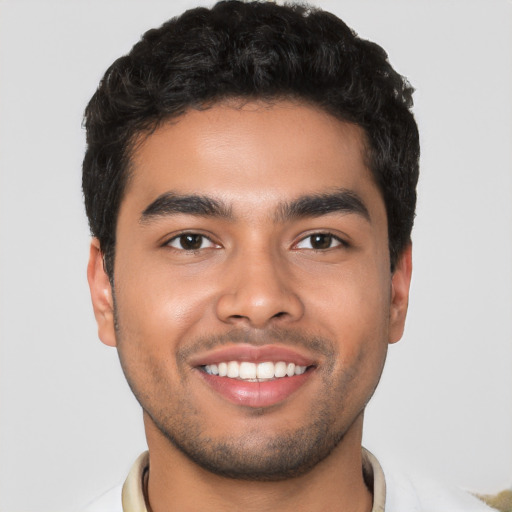 Joyful latino young-adult male with short  black hair and brown eyes