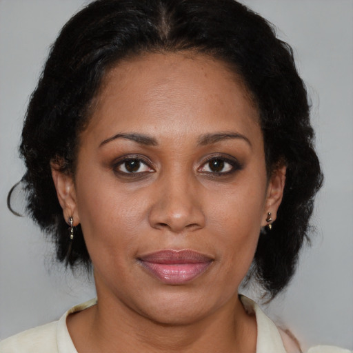 Joyful black adult female with medium  brown hair and brown eyes