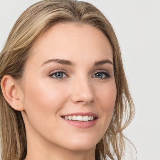 Joyful white young-adult female with long  brown hair and grey eyes