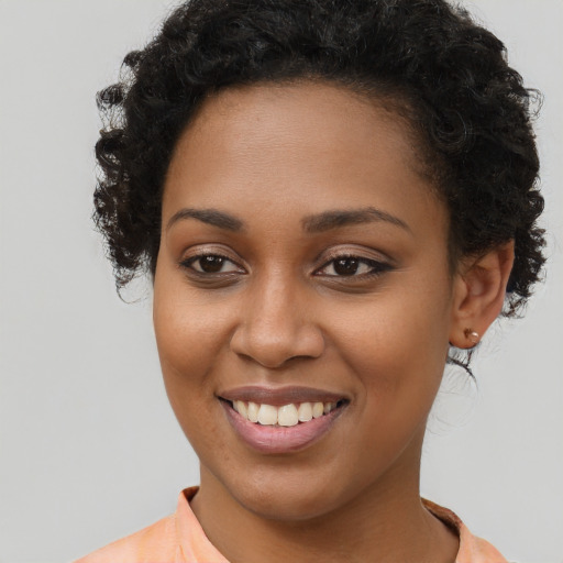Joyful black young-adult female with short  brown hair and brown eyes