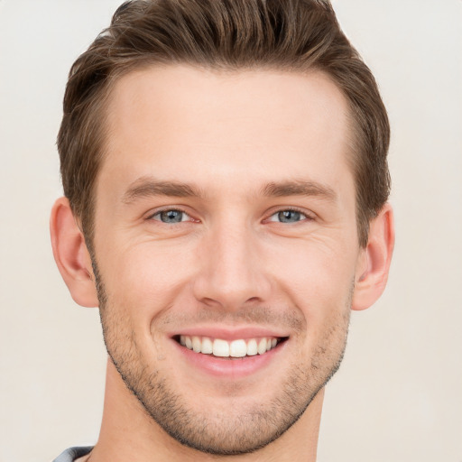 Joyful white young-adult male with short  brown hair and grey eyes