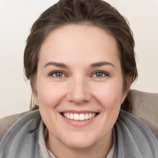 Joyful white young-adult female with medium  brown hair and grey eyes