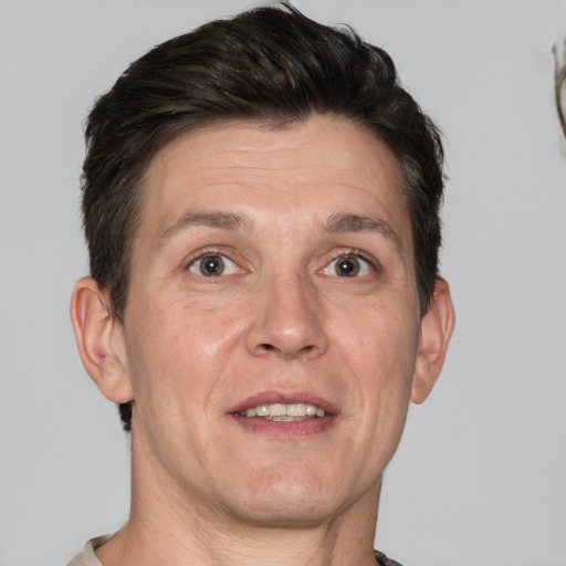 Joyful white adult male with short  brown hair and grey eyes